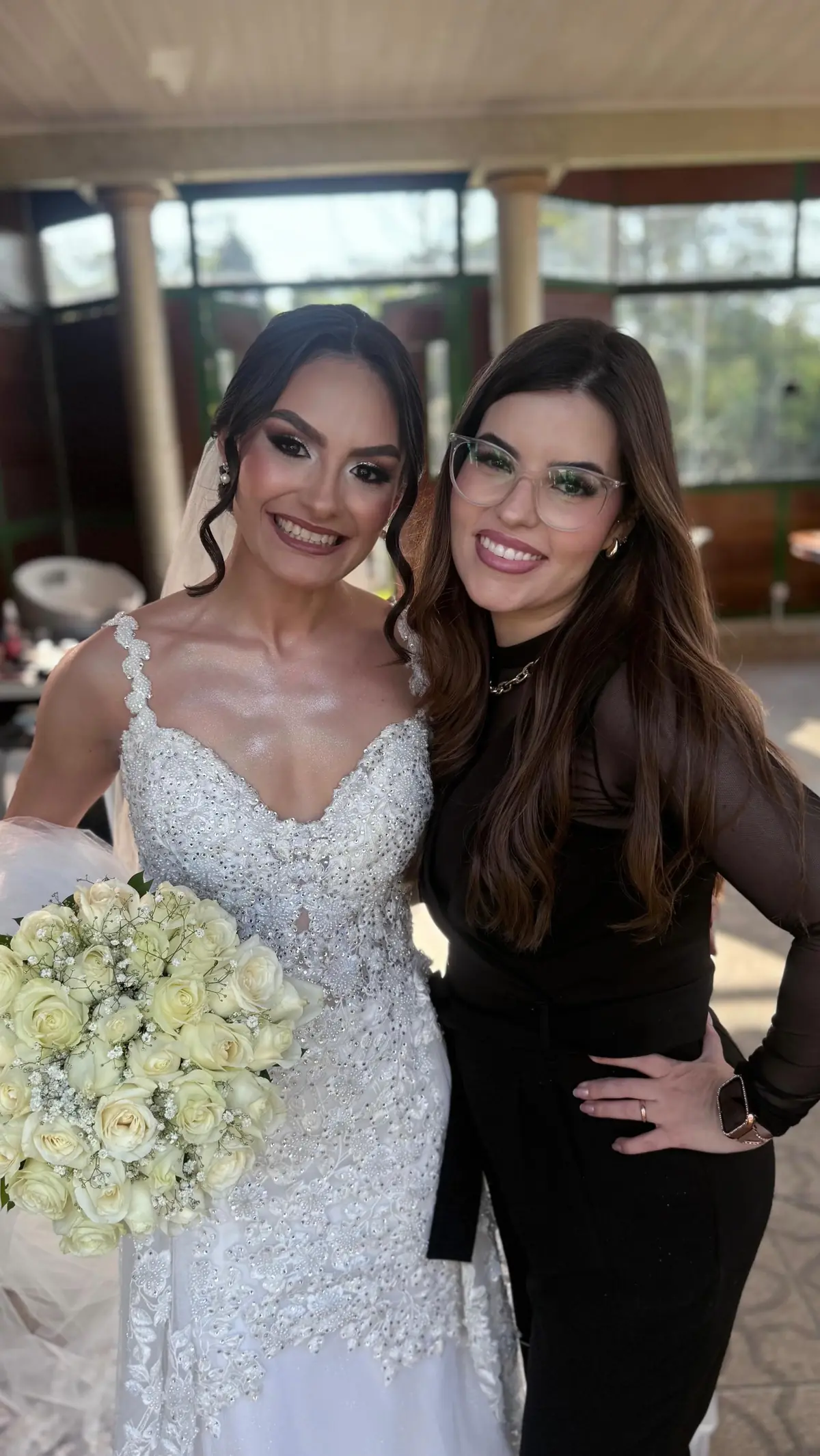 Alessandra Rodrigues, de óculos, abraçada à noiva Giovanna no dia do casamento